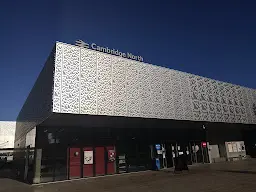 A very (intentionally) low resolution picture of Cambridge North station: a metallic silver box with 'Cambridge North' mounted atop it.